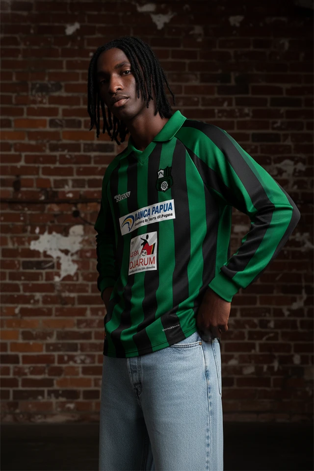 1765121193105-Jersey_Sepak_Bola_Lengan_Panjang_Garis_Hijau_Hitam_Retro_(AC_Wamena)_-_Dinamis___Era_90-an_Streetwear_(Tinggi)_-_Revisi__aku_butuh_pose_yang_berbeda_dengan_background_ini.webp